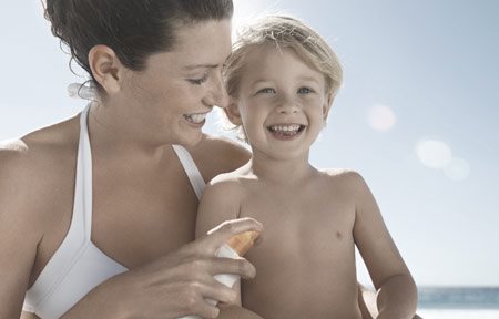 Matka při nanášení opalovacího krému