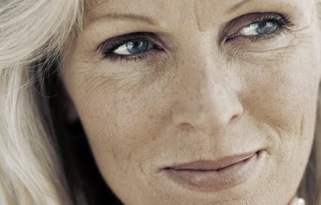 Starší žena s bílou pletí a stařeckými skvrnami