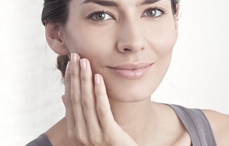 Žena aplikující krém na obličej 